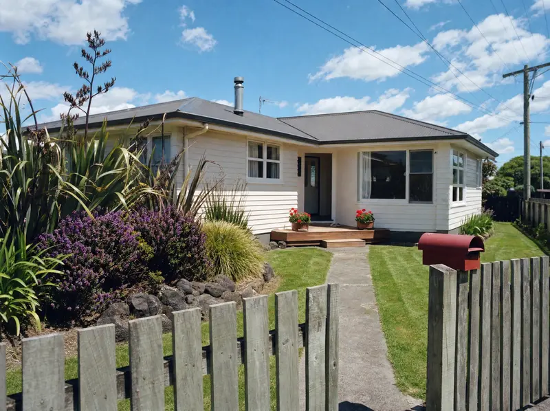 Well-maintained New Zealand suburban weatherboard home with native garden and corrugated iron roof
